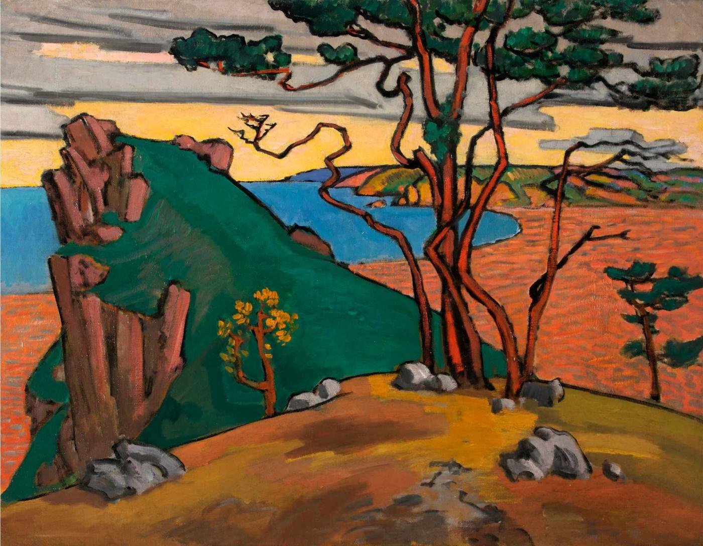 A bold, stylised landscape painting titled Studland Bay(1911) by Roger Fry. The scene features dramatic rocky cliffs and windswept trees overlooking a vibrant red-orange sea. In the foreground, tall, twisted trees with red-brown trunks rise from a patchy, ochre-toned ground scattered with grey rocks. To the left, a jagged green cliff descends into the sea, contrasting with the deep blue water and the warm tones of the sky and sea. The sky is painted in soft shades of yellow, orange, and grey, suggesting a dramatic sunset or sunrise.